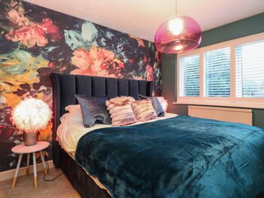 A bedroom with a bed and floral wallpaper at Tipsy Bee in Bowness-On-Windermere