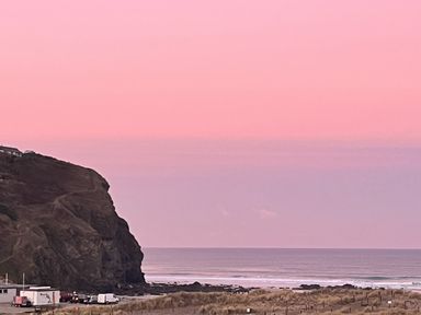A coastal scene with a cliff and sea at Kippy Cottage in Truro