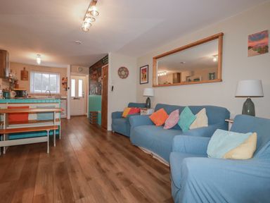 A living room with sofas and a table at Kippy Cottage in Porthtowan
