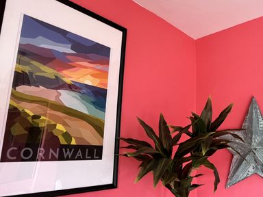 A picture frame with artwork and a plant at Kippy Cottage in Porthtowan