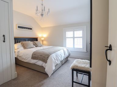 A bedroom with a bed lamp window and a stool at Glynside in Conwy