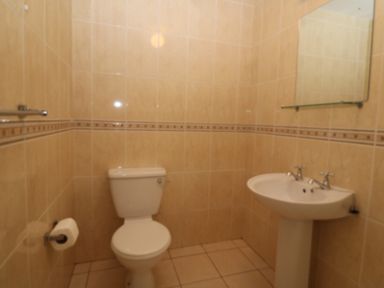 A bathroom with a toilet and a pedestal sink with dual taps at 14 Sneem Leisure Village in Sneem County Kerry