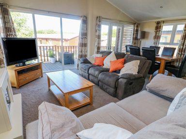 A living room with sofas a coffee table dining table and television at Gressingham 22 South Lakeland Leisure Village