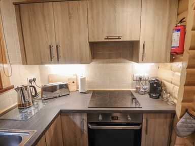 A kitchen countertop with a kettle toaster coffee machine and oven at Leafy Hollow Lodge in Louth