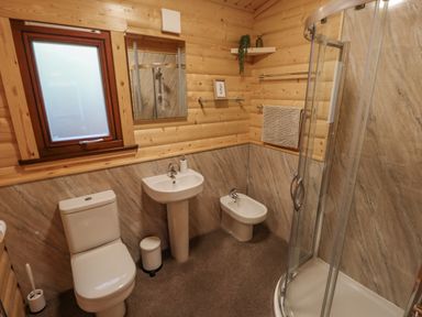 A bathroom with a toilet sink bidet and shower at Leafy Hollow Lodge in Louth