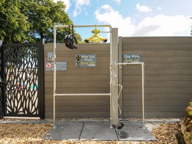An outdoor washing station with wetsuit hangers and a dog wash shower at Budock in Mawnan Smith Near Falmouth