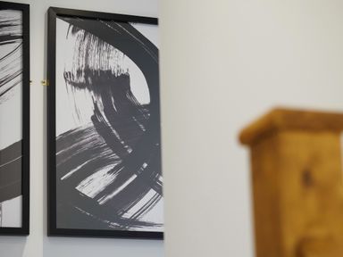 Black and white abstract framed artwork on a wall next to a wooden stair banister at Kerensa in Mawnan Smith Near Falmouth