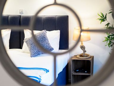 A bedroom with a bed a fluffy pillow a nightstand with a lamp and a plant in Coverack Mawnan Smith Near Falmouth