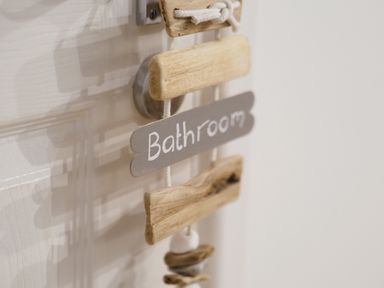 A wooden sign with the word Bathroom hanging on a door handle at Coverack in Mawnan Smith Near Falmouth
