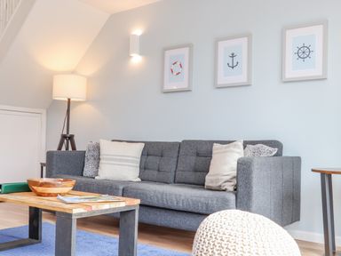 A living room with a gray sofa cushions a wooden coffee table and a floor lamp at Helford in Mawnan Smith Near Falmouth