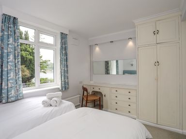 A bedroom with two single beds and a built-in wardrobe at Ynys Castell in Menai Bridge