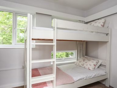 A bedroom with white bunk bed and butterfly pillows at Ynys Castell in Menai Bridge
