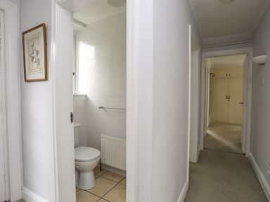 A hallway with doors leading to a bathroom and other rooms at Ynys Castell in Menai Bridge