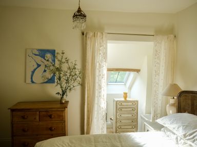 A bedroom with a wooden dresser and a bedside table with a lamp at Henllys in Newport Pembrokeshire