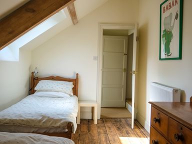 A bedroom with a single bed a wooden dresser and a framed picture on the wall at Henllys in Newport Pembrokeshire