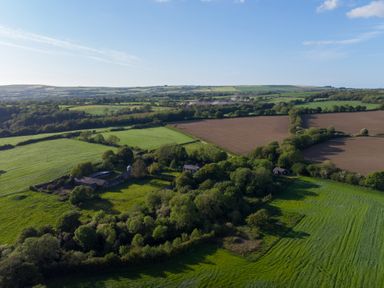 An aerial view of farmland with fields trees and buildings at Henllys Lodge in Newport Pembrokeshire