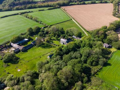 An aerial view of farmland with fields trees and buildings at Henllys Lodge in Newport Pembrokeshire