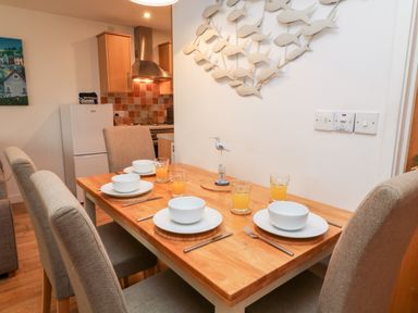 A dining table set with bowls plates glasses and cutlery in a kitchen area at Lilyvale Davidstow near Camelford
