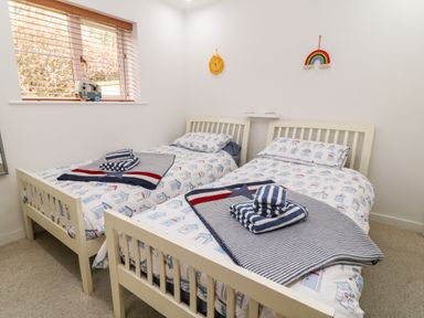 A bedroom with two single beds and striped towels on the beds at Lilyvale in Davidstow near Camelford
