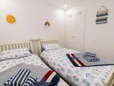A bedroom with two single beds with patterned bedding and towels on each bed at Lilyvale in Davidstow near Camelford