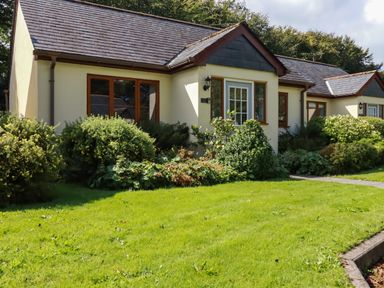 A single-story house with shrubs and a grassy lawn at Lilyvale in Davidstow near Camelford