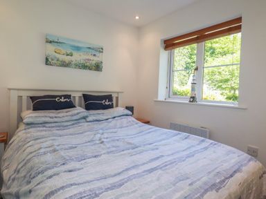 A bedroom with a bed and window at Lilyvale in Davidstow near Camelford