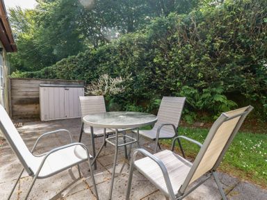 A garden with a table and chairs at Lilyvale in Davidstow near Camelford