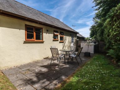 A patio area with a table and chairs at Lilyvale in Davidstow near Camelford