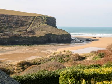A coastal landscape with sand beach cliffs and ocean at The Bright House in St Eval near St Columb Major