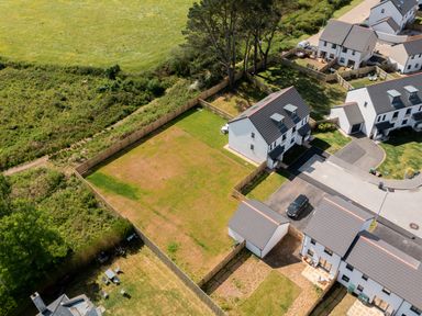 An aerial view of a residential area with fenced backyards lawns and houses at The Bright House in St Eval near St Columb Major