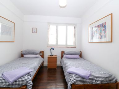 A bedroom with two single beds and a bedside table at Faraway in Rhosneigr