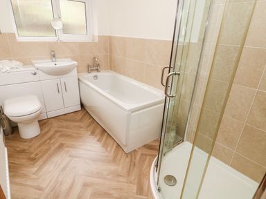 A bathroom with a bathtub sink toilet and corner shower at 8 Oaks Field in Ambleside