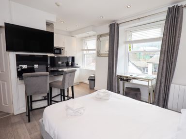 A studio room with a kitchen area and a bed at Bowness Central in Bowness-On-Windermere