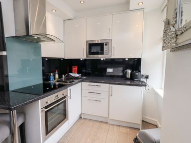 A kitchen with cabinets, microwave, oven, and countertop at Bowness Central in Bowness-On-Windermere