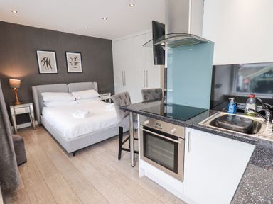 A studio apartment with a bed, kitchenette, and seating area at Bowness Central in Bowness-On-Windermere