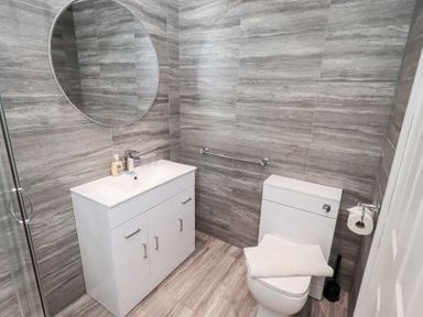 A bathroom with a sink, toilet and mirror at Bowness Central in Bowness-On-Windermere