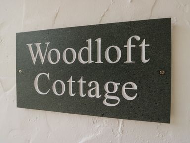 A sign displaying Woodloft Cottage at Woodloft Cottage Elterwater near Chapel Stile
