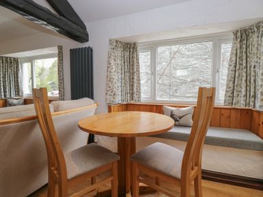 A dining area with a table and chairs at Woodloft Cottage Elterwater near Chapel Stile