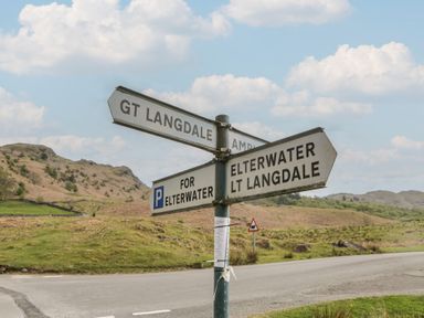 A signpost indicating directions to GT Langdale, Elterwater, and LT Langdale in Elterwater near Chapel Stile