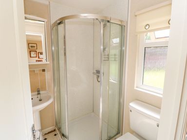 A bathroom with a corner shower enclosure a pedestal sink a toilet and a window at 6 Badgers Retreat Tunstall near Richmond