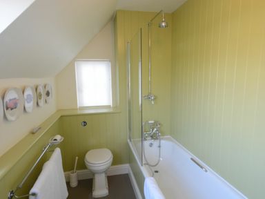 A bathroom with a bathtub shower toilet and towel rails at 2 The Dunes Thorpeness