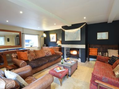 A living room with leather sofas a fireplace and a pool table at Durdans Walberswick in Walberswick
