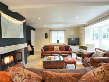 A living room with a fireplace a sofa and a television at Durdans Walberswick
