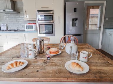 A kitchen with a table set for breakfast at Holly Lodge in Aldeburgh