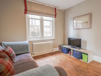 A living room with a sofa and television at Holly Lodge in Aldeburgh