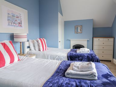 A bedroom with two beds and a dresser at Holly Lodge in Aldeburgh