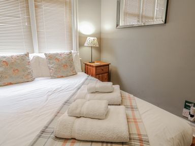 A bedroom with a bed and towels on it at Holly Lodge in Aldeburgh