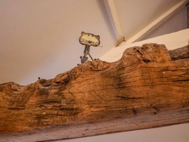 A wooden beam with a small cat-shaped metal decoration on top at Remus in Larling near East Harling