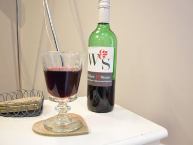 A glass of red wine and a bottle of Willow and Stone on a white table in Pied a Mer Aldeburgh in Aldeburgh