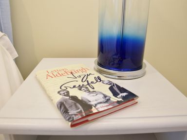 A book titled Letters from Aldeburgh on a white table next to a blue and white gradient lamp at Pied a Mer Aldeburgh